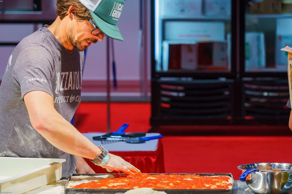 Шеф-пиццайоло готовит пиццу у открытой кухни Forno